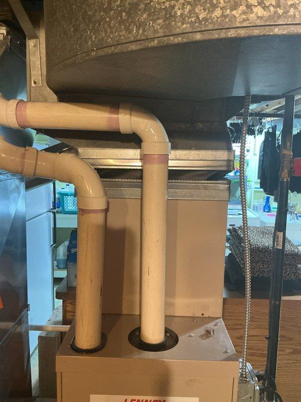 Provided comprehensive replacement estimate for 23-year-old basement-installed HVAC system including air conditioning unit and furnace with undetermined fuel type. Assessed existing equipment configuration showing aged ductwork, weathered metal enclosures, PVC drainage piping, and galvanized supply ducts with visible deterioration throughout the system. Documented current system layout and components to prepare detailed equipment replacement specifications, noting that portions of the existing system are experiencing operational failures.