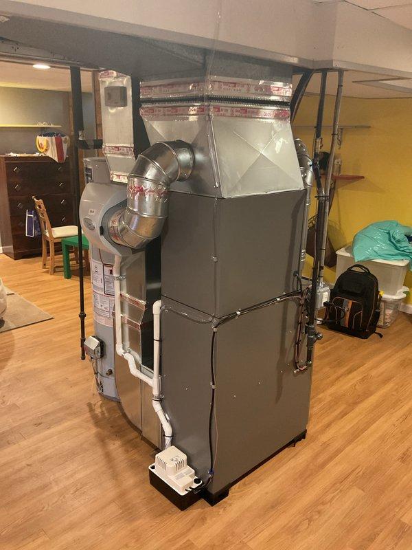 Completed full HVAC system installation in residential basement including a Lennox 70,000 BTU gas furnace (Model CK40CT-24A-7T) and 2-ton air conditioning unit with rear discharge configuration. Installation included proper ductwork connections, PVC venting and condensate drainage piping, electrical disconnects, and unit placement on protective base pad per manufacturer specifications. Mechanical and electrical permits were coordinated for this complete system replacement, with electrical reconnection work requiring licensed electrician to finalize power connections.