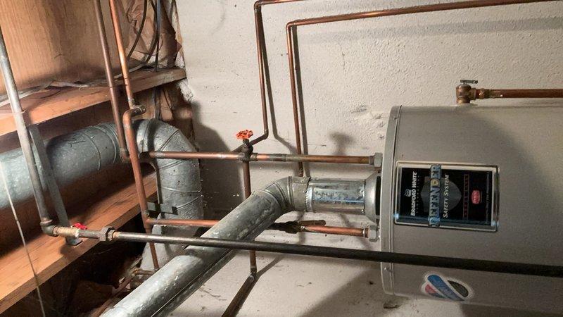 Completed comprehensive Gold AC Inspection on a multi-unit residential HVAC system with equipment over 10 years old. Inspected basement-located furnace/air handler unit with control panel, verified proper operation of digital displays and indicator lights, and examined associated copper refrigerant lines, shut-off valves, and expansion tank connections. Evaluated attic-mounted air handler unit with control interface, assessed flexible ductwork connections, inspected PVC condensate drainage lines and mounting brackets, and verified proper installation of electrical connections. Both systems confirmed operational with no immediate service needs identified during inspection.