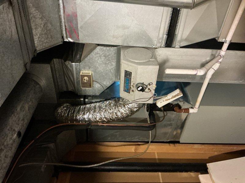 Completed comprehensive Gold AC Inspection on a multi-unit residential HVAC system with equipment over 10 years old. Inspected basement-located furnace/air handler unit with control panel, verified proper operation of digital displays and indicator lights, and examined associated copper refrigerant lines, shut-off valves, and expansion tank connections. Evaluated attic-mounted air handler unit with control interface, assessed flexible ductwork connections, inspected PVC condensate drainage lines and mounting brackets, and verified proper installation of electrical connections. Both systems confirmed operational with no immediate service needs identified during inspection.