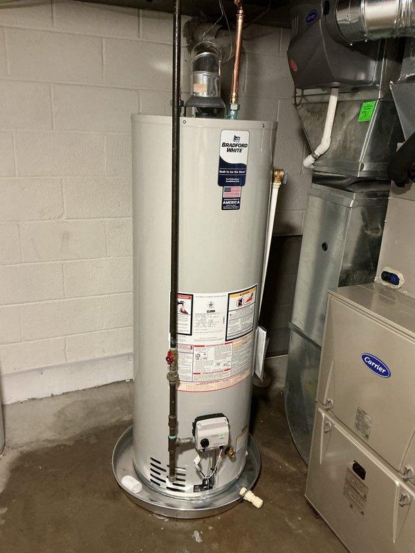 Completed installation of a 40-gallon Bradford White natural gas water heater (Model RG240T6N) in basement utility room. Unit was properly positioned, connected to existing copper supply lines, and vented according to manufacturer specifications with all safety clearances maintained. All connections were tested and verified operational with no leaks detected.