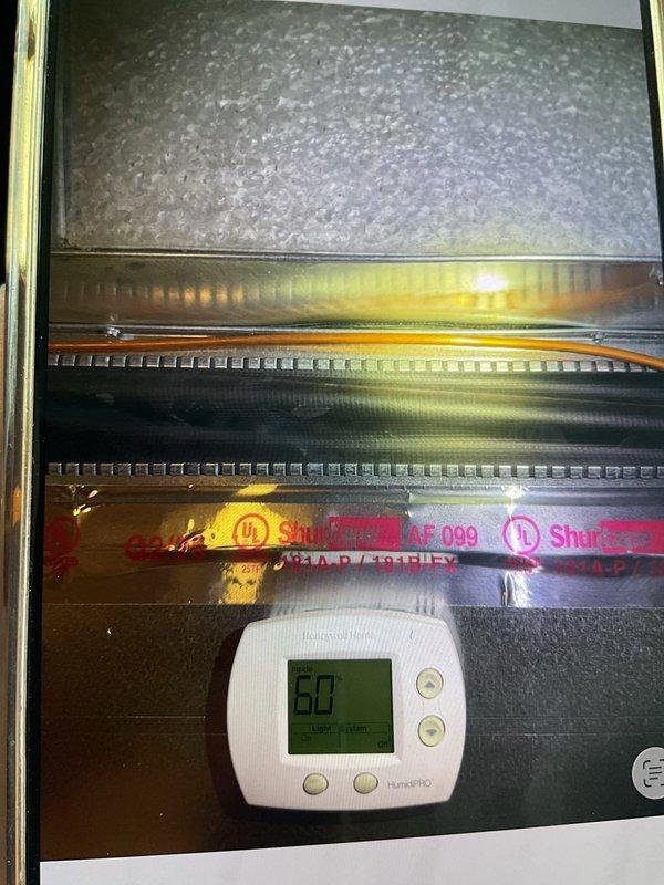Responded to customer complaint of loud boom noise occurring when air conditioning system shuts off. Inspected 1-year-old AC system and associated furnace/air handler unit located in basement. Upon examination, identified potential issue with ductwork expansion/contraction or damper operation causing audible noise during system shutdown. Performed visual inspection of heat exchanger, blower assembly, and cabinet interior. Documented equipment dimensions and current operational status with digital temperature readings showing 50°F at evaporator coil. Verified proper airflow through filter media and assessed metallic components for secure mounting. Advised homeowner on findings and recommended monitoring system performance through remainder of cooling season.