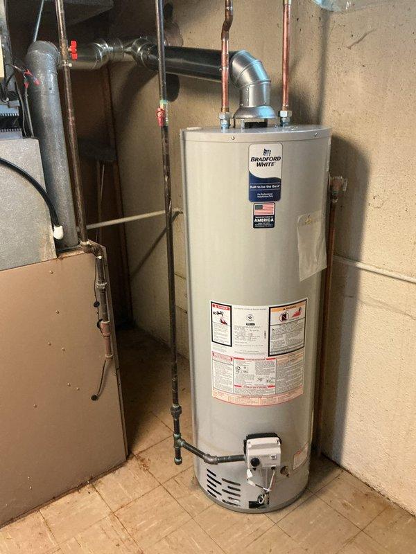 Installed a 40-gallon Bradford White tanked water heater in basement utility area. Connected hot and cold water supply lines using copper piping, installed temperature and pressure relief valve with proper discharge piping, and secured venting system with aluminum duct work. All plumbing connections were tested for leaks, unit was fired up and tested for proper operation, and installation meets current plumbing code requirements.