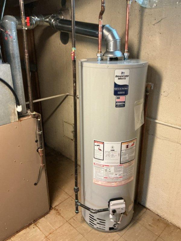Installed a 40-gallon Bradford White tanked water heater in basement utility area. Connected hot and cold water supply lines using copper piping, installed temperature and pressure relief valve with proper discharge piping, and secured venting system with aluminum duct work. All plumbing connections were tested for leaks, unit was fired up and tested for proper operation, and installation meets current plumbing code requirements.