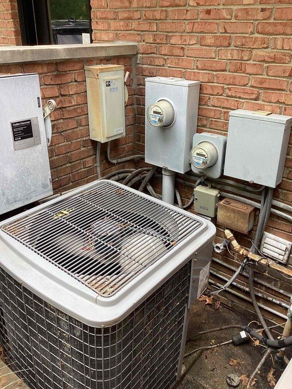 Provided comprehensive estimate for complete HVAC system replacement at lower level location, evaluating 20-year-old air conditioning condenser unit and furnace system that have reached end of serviceable life. Assessed outdoor AC unit mounted on concrete pad against brick exterior wall near electrical meters and indoor furnace equipment in mechanical room, documenting existing installation configurations, electrical connections, and spatial requirements for new equipment. Presented replacement options and specifications for modern high-efficiency heating and cooling systems to restore reliable climate control to the residence.