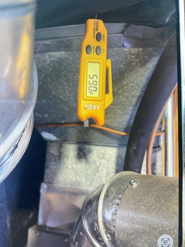 Responded to no cooling complaint on 2016 central air conditioning system. Upon arrival, confirmed unit was blowing warm air with inadequate temperature differential. Performed diagnostic temperature measurements at supply ductwork, recording wet bulb and dry bulb readings to assess system performance. Supply air temperature measured at 60.52°F WB and 50.5°F, indicating insufficient cooling capacity. Inspected outdoor condensing unit and refrigerant lines. Observed significant dust accumulation on ductwork and system components. Diagnostic testing completed to identify root cause of cooling failure.