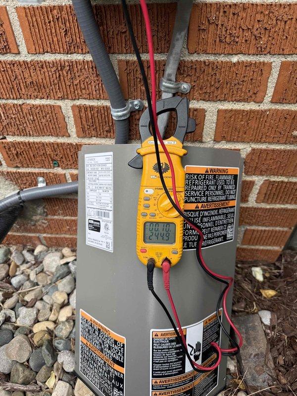 Completed comprehensive Gold AC Inspection on 10+ year old residential air conditioning system with outdoor condensing unit and basement-located air handler. Performed electrical diagnostics using digital multimeter to verify proper amperage draw and voltage levels at the outdoor unit. Inspected evaporator coil assembly through access grille, noting presence of condensation on coil fins indicating normal operation. System confirmed operational with no deficiencies identified during inspection. All components functioning within normal parameters.