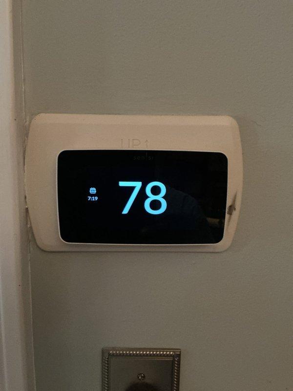 Responded to service call for 10-year-old air conditioning system with inadequate cooling performance. Upon arrival, confirmed thermostat was set to 78°F and assessed both indoor air handler unit located in basement and outdoor condenser unit. Performed diagnostic evaluation of the system with suspected compressor failure as the primary concern. Documented current system conditions through photographs of thermostat display and exterior condenser unit positioned against building exterior. Condenser unit showed normal exterior condition with no visible signs of physical damage, excessive wear, or refrigerant leakage around cabinet or connections.