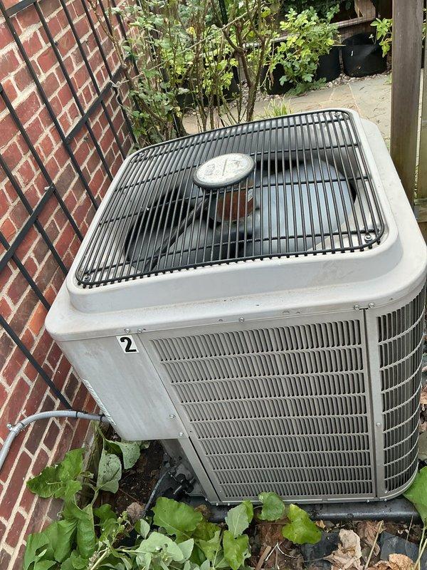 Responded to service call for 10-year-old air conditioning system with inadequate cooling performance. Upon arrival, confirmed thermostat was set to 78°F and assessed both indoor air handler unit located in basement and outdoor condenser unit. Performed diagnostic evaluation of the system with suspected compressor failure as the primary concern. Documented current system conditions through photographs of thermostat display and exterior condenser unit positioned against building exterior. Condenser unit showed normal exterior condition with no visible signs of physical damage, excessive wear, or refrigerant leakage around cabinet or connections.