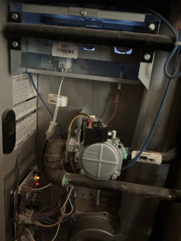 Completed comprehensive tune-up and inspection on 20+ year old furnace and air conditioning system. Inspected gas valve assembly, electrical connections, and control components in furnace located in utility room; verified proper operation and connections of all wiring harnesses. Performed exterior condenser unit inspection, checking fan operation, refrigerant lines, electrical conduit connections, and ensuring adequate clearance around unit mounted on concrete pad.