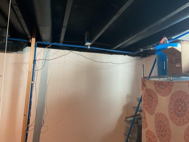 Conducted site assessment for installation of second water meter at residential property. Evaluated existing plumbing infrastructure in basement area, including current water service entry point, copper supply lines, and available space for additional metering equipment. Documented existing conditions through photographs showing ceiling-mounted piping, water heater connections, and structural layout to determine optimal routing and installation location for secondary meter assembly.