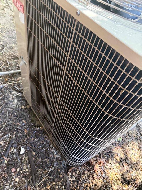 Completed comprehensive Gold AC Inspection on 20-year-old residential air conditioning system with evaporator coil located in basement and condenser unit positioned outdoors. Performed electrical diagnostics using digital clamp meter, recording voltage and amperage readings at the outdoor unit to verify proper system operation and component functionality. Conducted thorough visual inspection of condenser unit exterior, coil condition through protective grille, and internal wiring connections to assess overall system health and identify any maintenance concerns associated with the aging equipment.