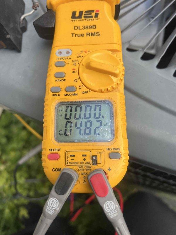 Responded to no cooling complaint on 10-year-old residential air conditioning system. Upon arrival, performed diagnostic evaluation of outdoor condenser unit located in backyard. Unit was running but failing to produce cold air. Conducted visual inspection of condenser coils, fan operation, and overall unit condition, noting age-related wear on exterior components. Utilized digital multimeter to test electrical components and verify proper voltage and amperage readings throughout the system. Measurements indicated potential refrigerant or compressor-related issue affecting cooling capacity. Documented equipment condition with photographs showing weathered condenser unit with horizontal coil fins and cylindrical fan assembly. Provided customer with diagnostic findings and recommended next steps for repair or replacement consideration given the system's age and current performance issues.