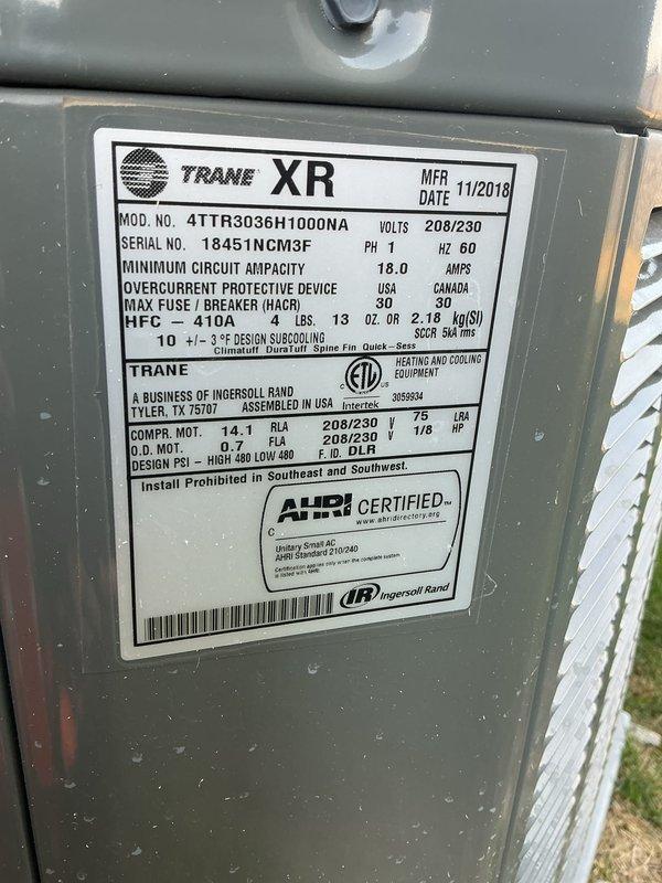Completed comprehensive Gold AC Inspection on a 6-year-old Trane XR system (Model: 4TTR3036H1000NA, manufactured 11/2019) with 410A refrigerant. Performed full seasonal tune-up including inspection of condenser unit mounted on concrete pad, verified electrical specifications (208/230V, 18.0 amps), checked compressor and condenser motor operation, inspected fan assembly and protective grille, confirmed proper airflow through louvered panels, and examined refrigerant lines and drainage. Unit operating within manufacturer specifications with no deficiencies noted; system ready for cooling season.