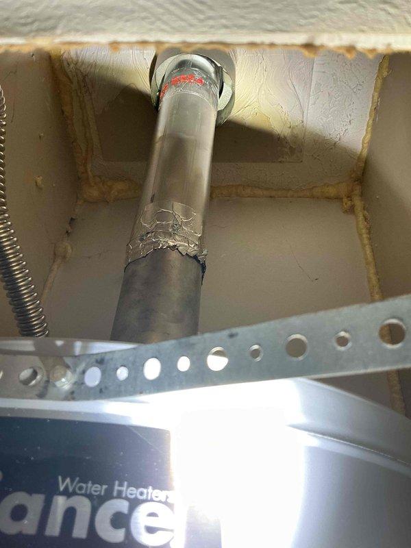 Performed draft test on 2024 model hot water heater located in bedroom closet. Utilized digital pressure measurement device to conduct diagnostic testing on the unit, with readings indicating proper pressure levels at 003 PSI on both P1 and P2 gauges. Inspected vent pipe assembly and noted visible deterioration on the metal flue pipe surface with peeling material present on the middle section. Verified proper venting connection from water heater top through insulated enclosure, though vent pipe showed signs of aging and surface corrosion requiring monitoring for future replacement consideration.