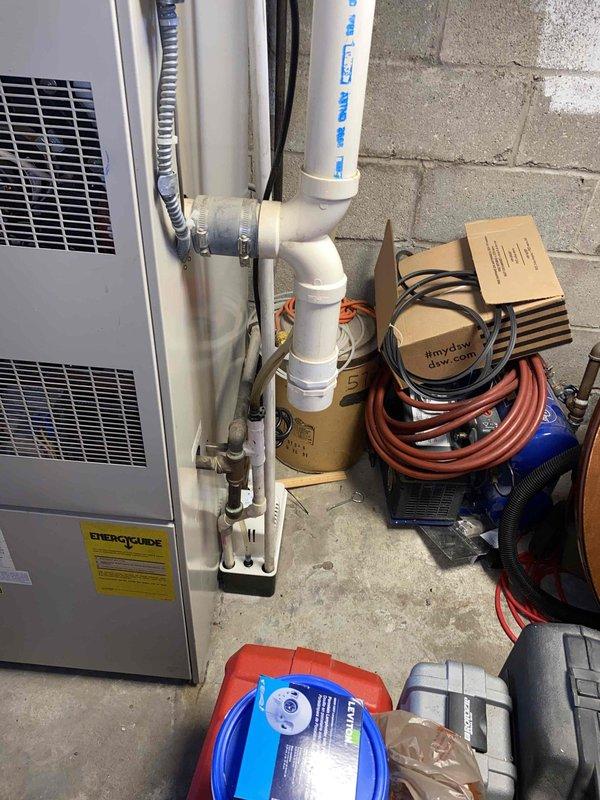 Completed comprehensive estimate for replacement of 10+ year old air conditioning and furnace system located in basement. Assessed existing HVAC equipment, documented current installation including white cabinet-style unit with associated PVC condensate drainage system, and evaluated infrastructure requirements for new system installation. Photographed equipment location, available workspace, existing ductwork connections, and utility access points to provide accurate replacement specifications and equipment recommendations.