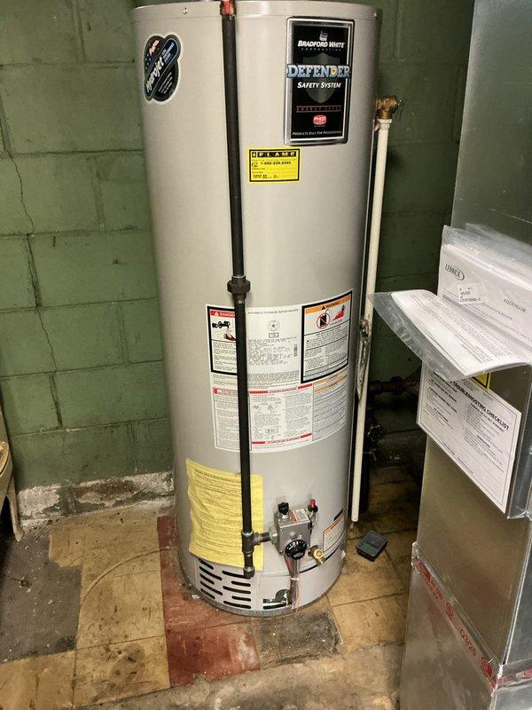Responded to no hot water complaint in 1939-built residence. Upon inspection, found existing tanked water heater failing to produce adequate hot water for over a week. Evaluated unit condition, age, and performance issues affecting all household fixtures and appliances. Installed new Bradford White tanked water heater with integrated safety system to replace failing unit. Connected all supply and discharge piping, verified proper gas line connections, tested temperature and pressure relief valve operation, and confirmed proper venting. Cycled unit through complete heating cycle to verify full restoration of hot water throughout home. All connections tested leak-free and system operating within manufacturer specifications.
