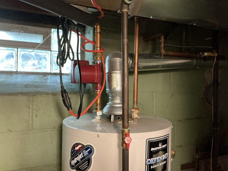 Responded to no hot water complaint in 1939-built residence. Upon inspection, found existing tanked water heater failing to produce adequate hot water for over a week. Evaluated unit condition, age, and performance issues affecting all household fixtures and appliances. Installed new Bradford White tanked water heater with integrated safety system to replace failing unit. Connected all supply and discharge piping, verified proper gas line connections, tested temperature and pressure relief valve operation, and confirmed proper venting. Cycled unit through complete heating cycle to verify full restoration of hot water throughout home. All connections tested leak-free and system operating within manufacturer specifications.