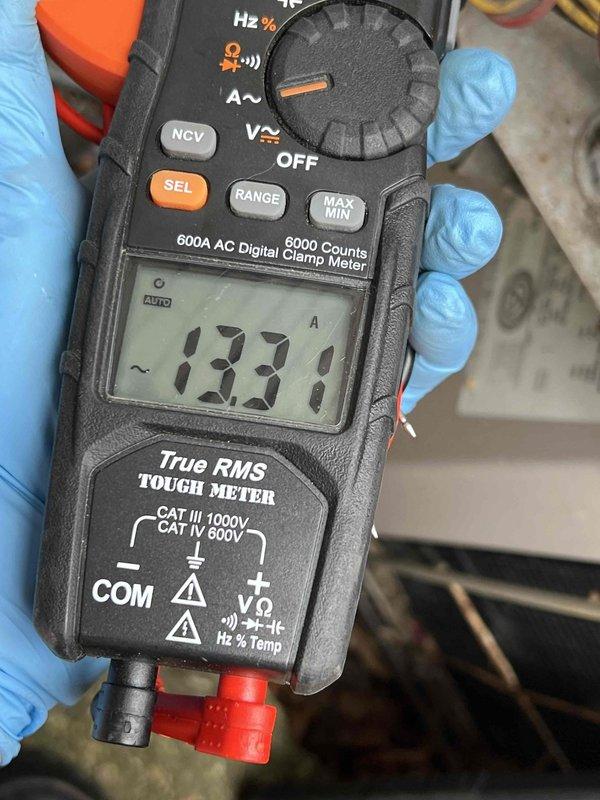 # No Heat Service Call - 10-Year-Old Furnace

Responded to no heat condition on first-floor heating and cooling system. Upon arrival, confirmed furnace was not operational. System age approximately 10 years. Performed diagnostic testing using digital clamp meter to measure electrical amperage, recording 13.31 amps draw. Inspected thermostat and found wall damage around mounting location with exposed cavity behind drywall. Assessed thermostat wiring connections and mounting integrity. Documented equipment condition and electrical readings with photographs for service records. System required further evaluation of thermostat installation and potential wall repair to ensure proper operation and secure mounting of control devices.