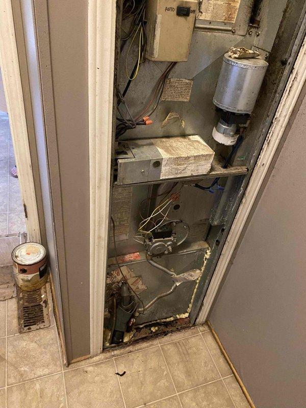 Performed estimate for complete furnace replacement in 1999 mobile home with 27-year-old heating system located in laundry room utility closet. Assessed existing HVAC equipment configuration including aged blower assembly, furnace components, and electrical connections showing significant wear and dust accumulation in vertically-stacked installation. Documented current system condition, exterior condensing unit on concrete pad, and discussed financing pre-qualification options with homeowner for upcoming replacement project.