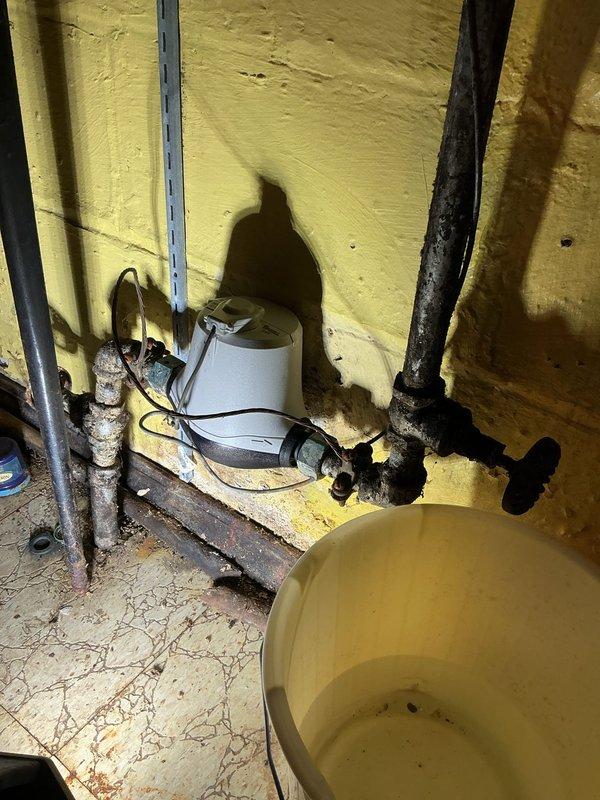 Responded to service call for corroded main water shutoff valve preventing proper water isolation to the residence. Upon inspection, discovered heavily corroded gate valve and associated piping in basement utility area showing extensive oxidation and deterioration. Valve mechanism seized due to corrosion, rendering it inoperable and creating potential emergency situation where water supply cannot be shut off in case of plumbing failure. Documented existing conditions including rusted support brackets, degraded floor surfaces, and aging plumbing infrastructure. Advised homeowner that main shutoff valve requires replacement to restore proper water control functionality and prevent potential water damage from inability to isolate water supply during emergency situations.