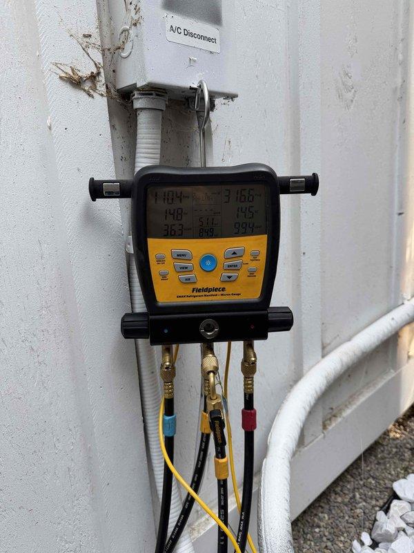 Completed comprehensive Gold AC inspection on 3-year-old residential air conditioning system with outdoor condenser unit and basement air handler. Performed full system diagnostics using digital manifold gauges to measure refrigerant pressures and temperatures, verifying proper charge levels and system performance. Inspected outdoor condenser unit positioned on concrete pad, confirming proper airflow through louvered panels, operational fan assembly, and secure refrigerant line connections. Evaluated electrical disconnect, examined condensate drainage, and assessed overall equipment condition. System operating within manufacturer specifications with no deficiencies noted at time of inspection.