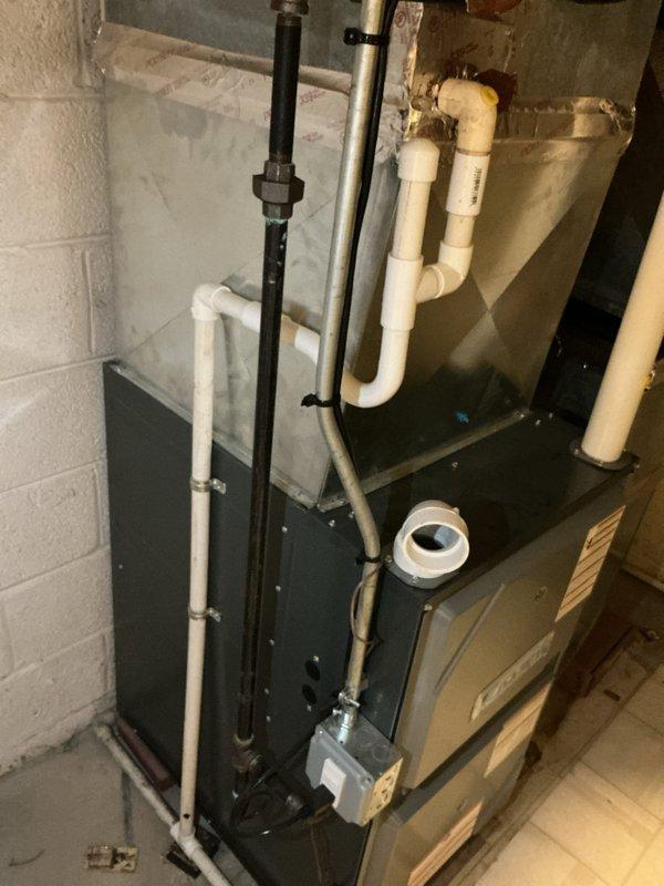 Completed comprehensive HVAC system inspection and replacement estimate for multi-unit residential property with equipment exceeding 10 years of service life. Assessed existing high-efficiency furnace system located in basement, including evaluation of venting configuration with multiple PVC exhaust and intake pipes, condensate drainage components, and ductwork condition. Documented current system layout featuring gas furnace with associated copper refrigerant lines, black iron gas piping, and sheet metal supply duct with visible dust accumulation, providing homeowner with detailed replacement options and equipment recommendations for aging HVAC infrastructure.
