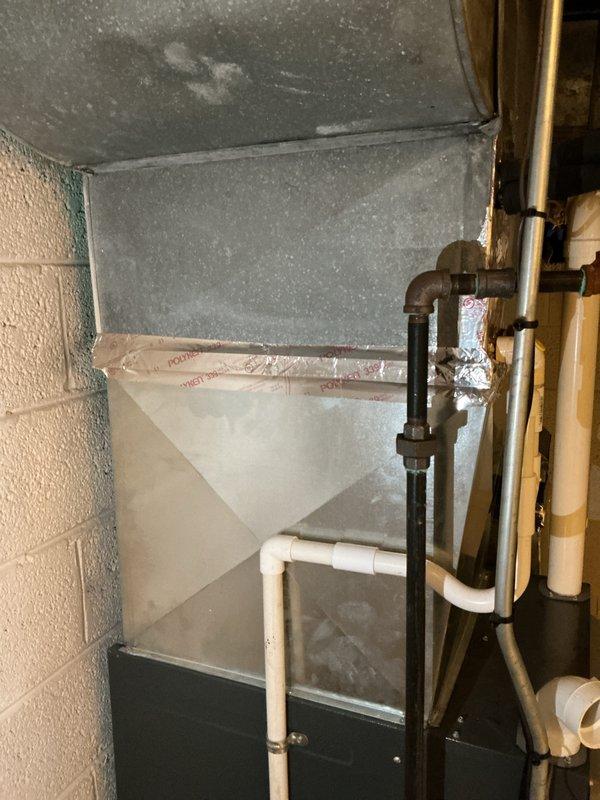 Completed comprehensive HVAC system inspection and replacement estimate for multi-unit residential property with equipment exceeding 10 years of service life. Assessed existing high-efficiency furnace system located in basement, including evaluation of venting configuration with multiple PVC exhaust and intake pipes, condensate drainage components, and ductwork condition. Documented current system layout featuring gas furnace with associated copper refrigerant lines, black iron gas piping, and sheet metal supply duct with visible dust accumulation, providing homeowner with detailed replacement options and equipment recommendations for aging HVAC infrastructure.