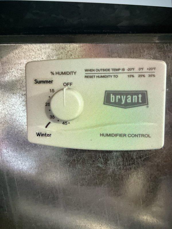 Completed comprehensive Gold AC inspection on 12-year-old single-zone system with basement air handler and outdoor condenser unit. Inspected Bryant humidifier control panel, verified proper operation of outdoor condensing unit with functional fan assembly, examined refrigerant line insulation and electrical disconnect, and documented system components. All equipment operational at time of inspection with no immediate service needs identified.