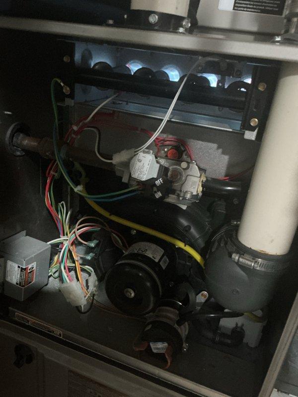 Completed comprehensive Gold AC and furnace inspection on 10+ year old HVAC system with outdoor condenser unit and basement-located air handler. Performed thorough visual examination of gas furnace internal components including burner assembly with operational blue flame openings, gas valve assembly with proper wire connections, blower motor assembly, and PVC condensate drainage system. Inspected outdoor condenser unit including fan motor operation, protective wire guard integrity, and overall cabinet condition showing normal weathering consistent with age. All equipment found operational with no immediate safety concerns identified. Documented system condition with photographic evidence showing standard wear patterns appropriate for equipment age. Both heating and cooling systems confirmed functional at time of inspection.
