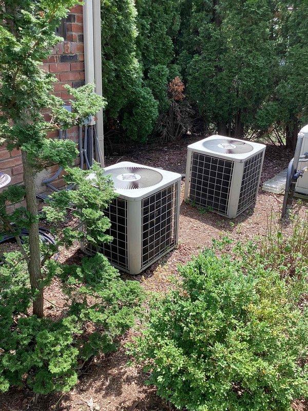 Completed comprehensive annual safety inspection and tune-up on 35-year-old dual-zone air conditioning system with two outdoor condenser units and air handlers located in attic and basement. Performed full system evaluation including refrigerant levels, electrical connections, condensate drainage, airflow measurements, and component operation testing on both zones. Documented equipment condition with photographic evidence showing outdoor condensers positioned on gravel pad with adequate clearance, and attic air handler installation with visible ductwork and insulation configuration.