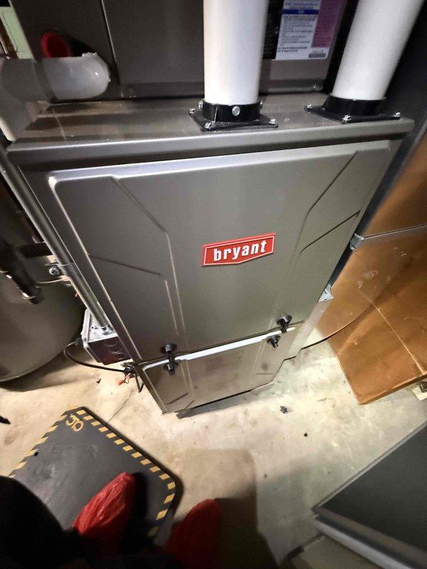 Completed comprehensive Gold AC Inspection on 13-year-old Bryant HVAC system with basement-located air handler and outdoor condensing unit. Performed multi-point inspection including visual assessment of indoor air handler cabinet, PVC vent piping integrity, and outdoor condenser unit with louvered side panels and heat exchanger coils. System confirmed operational at time of inspection with all major components functioning within normal parameters; documented equipment condition through photographic records showing both indoor and outdoor units in serviceable condition.