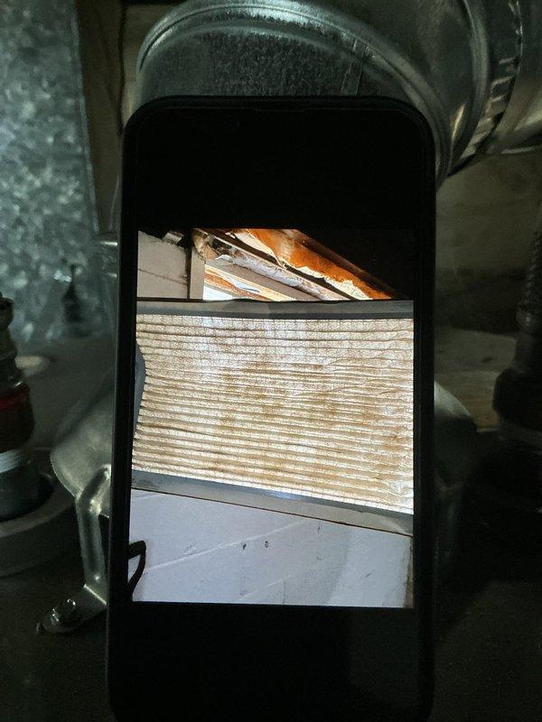 Responded to no-cool complaint on 2-year-old residential air conditioning system with reported freezing condition. Performed diagnostic inspection of indoor air handler unit located in basement and outdoor condensing unit. Accessed control board and internal components to check electrical connections and system operation. Inspected air filter condition and found moderate dust accumulation restricting airflow. Evaluated evaporator coil access area and blower assembly operation. Identified airflow restriction as primary cause of coil freezing issue. Recommended filter replacement and verified proper system operation following service. System restored to normal cooling function with adequate airflow through evaporator coil.