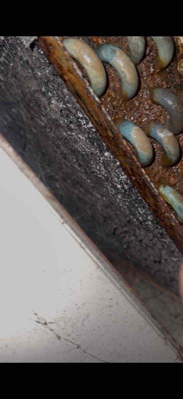 Responded to service call for potential water leak on 10+ year old SpacePack unit located in attic space. Upon inspection, discovered extensive corrosion on evaporator coil assembly and surrounding metal components, indicating prolonged moisture exposure. Heavy rust buildup observed on coil fins and metal framework, with significant oxidation present throughout the unit. The deteriorated condition of the coil and advanced corrosion patterns confirmed active condensate drainage issues contributing to moisture accumulation in the attic space. Documented equipment condition with photographic evidence showing corroded evaporator coil assembly and compromised structural integrity of metal components. Advised customer that evaporator coil replacement would be necessary due to extent of corrosion damage, as the unit's age and deterioration level make repair unfeasible. Recommended full system evaluation to determine most cost-effective solution given equipment age and current condition.