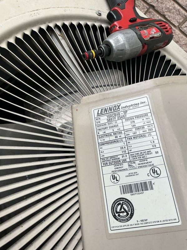 Responded to no cooling complaint on 6-year-old Lennox model 10ACB48-2G7 air conditioning unit located in basement. Upon inspection, discovered severely corroded electrical junction box with deteriorated housing and compromised wire connections using red wire nuts. Extensive rust, moisture damage, and debris accumulation present around electrical enclosure indicated prolonged exposure to adverse environmental conditions. Assessed outdoor condenser unit fan assembly and verified manufacturer specifications. Documented significant corrosion on vertical conduit and junction box requiring immediate attention due to safety concerns and impact on system performance. Electrical connection degradation identified as contributing factor to cooling system failure.