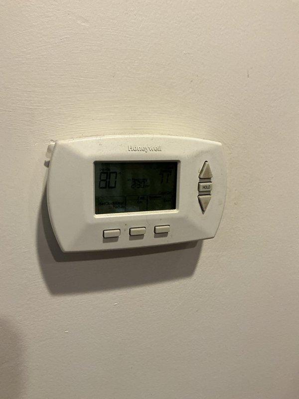 Responded to no cooling complaint on 25-year-old Carrier air conditioning system with evaporator coil connected to basement furnace. Upon arrival, found thermostat displaying 80 degrees and system not maintaining setpoint. Performed diagnostic evaluation of complete HVAC system including furnace cabinet, refrigerant lines, condensate drainage, and thermostat operation. Documented existing equipment conditions through photographic records showing Carrier furnace unit with PVC venting, associated ductwork, and Honeywell digital thermostat. Due to advanced age of equipment exceeding typical service life expectancy, provided homeowner with assessment of system condition and recommended replacement options for reliable cooling performance.