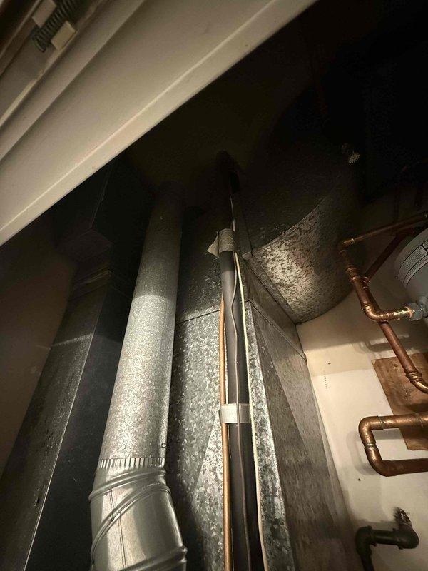 Responded to commercial AC unit with fan running but no cooling. Upon inspection, discovered extensive frost and ice buildup on supply ductwork in mechanical room, indicating refrigerant system failure or airflow restriction. Diagnosed low refrigerant charge as primary cause, resulting in evaporator coil freezing and blocking airflow to conditioned space. System shutdown required to allow coil defrost before proceeding with refrigerant recovery, leak detection, and recharge to restore proper cooling operation.