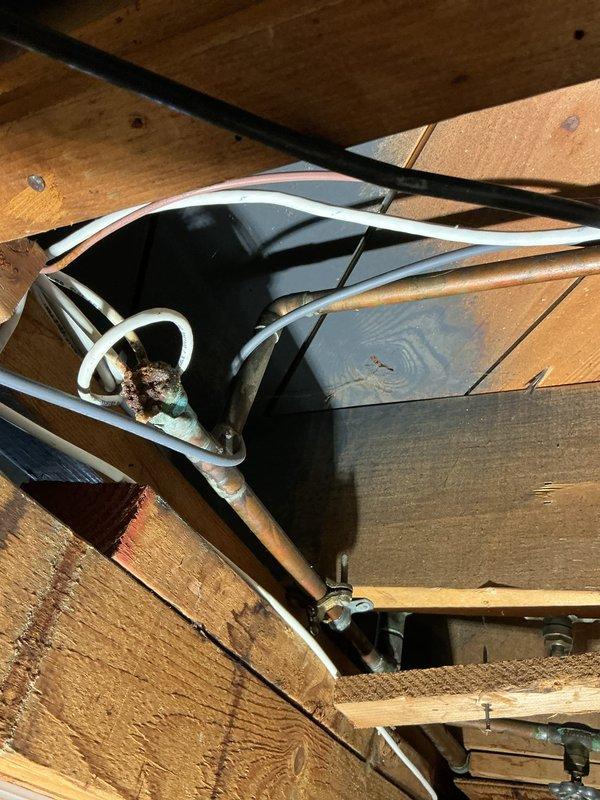 Responded to service call for outdoor spigot experiencing low water pressure with additional safety concern regarding water line proximity to electrical panel. Upon inspection, identified corroded copper supply line running through structural framing directly above main electrical service equipment, creating potential code violation and safety hazard.

Relocated outdoor spigot assembly away from electrical panels to ensure proper clearance and compliance with safety standards. Rerouted water supply piping through alternative path in crawl space, utilizing new copper piping to replace deteriorated sections showing significant oxidation and corrosion at connection points. Secured new pipe run to floor joists with appropriate hangers and brackets to prevent future sagging or movement.

Installed new exterior-grade spigot fixture on brick wall at approved location, ensuring proper mounting to structure with weatherproof backing plate. Tested water pressure at new spigot location, confirmin