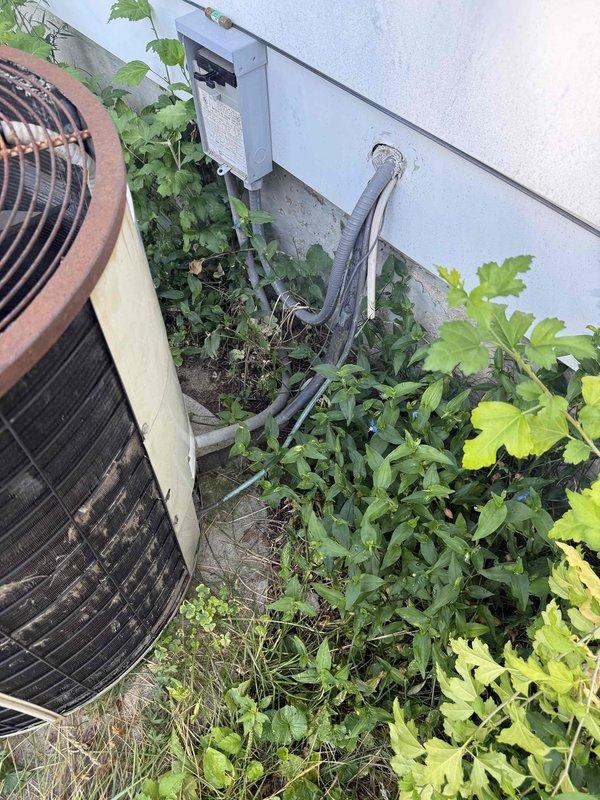 Responded to a no-cooling complaint on an approximately 30-year-old central air conditioning system that had previously received refrigerant charge and fuse replacement from another contractor. Upon arrival, performed comprehensive system evaluation and second-opinion diagnostic assessment of outdoor condensing unit, which exhibited severe external corrosion, rust deterioration throughout cabinet and top panel, and significant neglect with overgrown vegetation obstructing airflow and service access. Inspected condenser fan motor assembly through heavily corroded access port and confirmed previous diagnosis of failed fan motor. Evaluated compressor operation, electrical components, refrigerant lines, and overall system condition. Documented extensive rust damage to cabinet, heat exchanger surfaces, and mounting hardware indicating prolonged exposure to moisture and lack of preventative maintenance. Given the advanced age of equipment, severity of corrosion, and compromised structural in