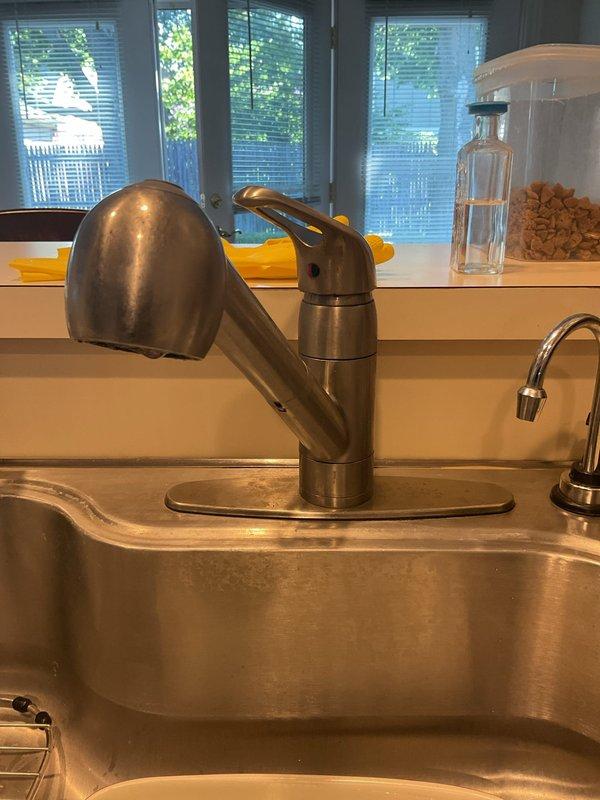 Responded to service call for kitchen sink leak originating from beneath the basin. Upon inspection of the cabinet interior, identified water damage on cabinet floor and examined all plumbing connections including garbage disposal unit, drain assembly, and supply lines. Inspected stainless steel double-basin sink with pull-out faucet and soap dispenser for source of leak. Evaluated all visible PVC drain pipes, flexible supply hoses, and disposal connections for signs of moisture, loose fittings, or deteriorated seals.