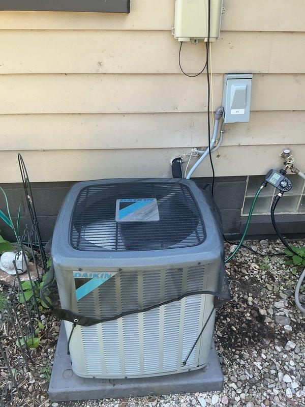 Responded to service call for AC unit not cooling properly with suspected low refrigerant. Upon arrival, inspected 6-year-old Daikin outdoor condensing unit and indoor air handler system. Performed system diagnostics including temperature differential measurements, visual inspection of refrigerant lines, and operational testing. Confirmed unit was operational but running with reduced cooling capacity. Checked electrical connections at outdoor disconnect, inspected condenser coil for debris and airflow restrictions, and verified proper fan operation. Documented equipment condition with photographs of both indoor furnace/air handler assembly and outdoor condensing unit for service records.