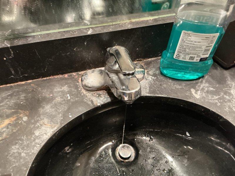 Responded to service call for faucet repair at residential bathroom sink. Upon inspection, assessed single-handle chrome faucet on black granite composite countertop for reported issue. Performed necessary repairs to restore proper faucet operation and functionality. Verified water flow, tested handle operation, and confirmed no leaks present at fixture or supply connections upon completion.