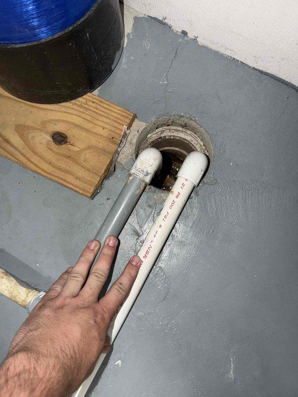 Responded to service call for water leaking from furnace during air conditioning operation at basement-located Payne air handler unit of undetermined age. Upon inspection, identified condensate drainage issue causing water accumulation. Addressed problematic condensate drain line configuration where PVC drainage pipes were improperly installed or blocked, preventing proper water evacuation from the evaporator coil. Cleared obstruction, verified proper drainage flow, and ensured condensate line was functioning correctly to eliminate water leakage issue.