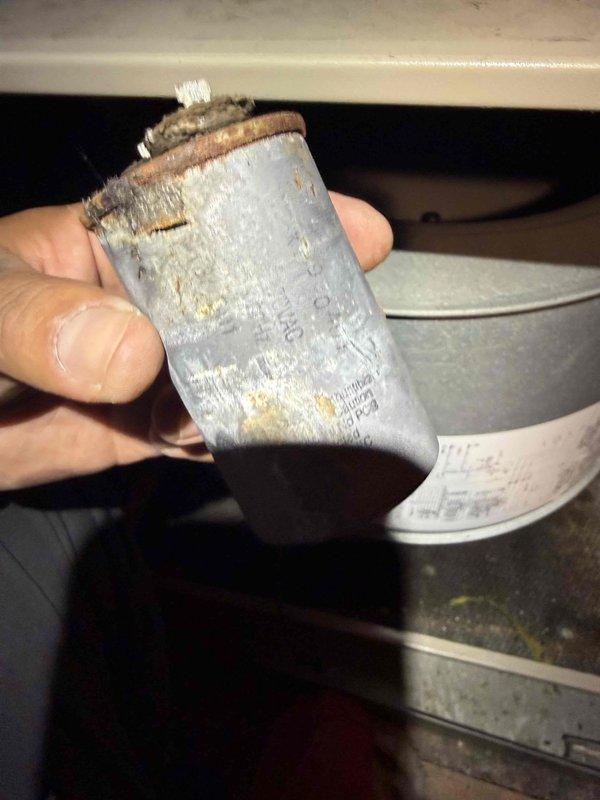 Completed Gold AC inspection on two residential HVAC systems: a 29-year-old unit and a 15-year-old unit, both with air handlers located in the attic. Performed comprehensive multi-point inspection including visual assessment of outdoor condenser unit, which showed standard wear and debris accumulation around the base. Removed and inspected capacitor from one system, which exhibited significant corrosion, discoloration, and rust around terminal connections, indicating component degradation and potential failure risk. Documented equipment condition with photographic evidence showing aged electrical components and exterior unit placement. Advised homeowner of weather-dependent inspection protocols for attic-mounted equipment to ensure accurate system performance evaluation and safety compliance.