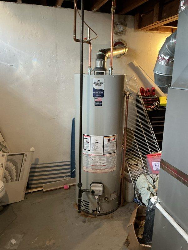 Installed a 40-gallon Bradford White tank-style water heater in basement mechanical room. Connected copper supply lines, gas piping, and metal exhaust vent according to manufacturer specifications and local code requirements. Unit is fully operational with all safety labels visible and proper clearances maintained from adjacent HVAC equipment.