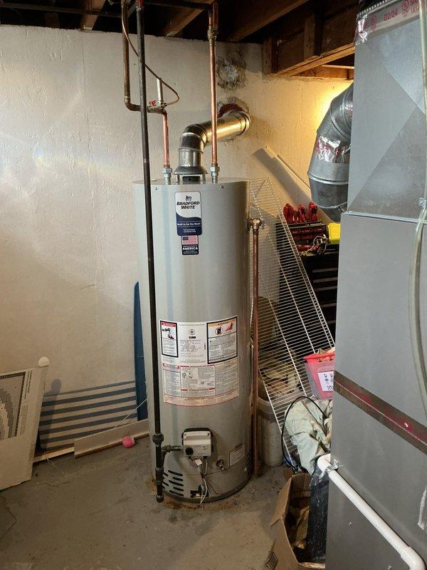 Installed a 40-gallon Bradford White tank-style water heater in basement mechanical room. Connected copper supply lines, gas piping, and metal exhaust vent according to manufacturer specifications and local code requirements. Unit is fully operational with all safety labels visible and proper clearances maintained from adjacent HVAC equipment.