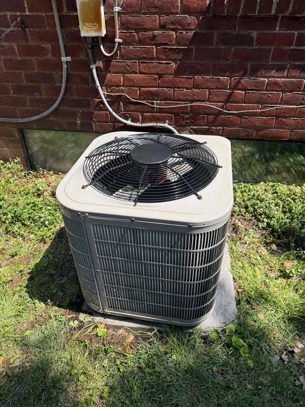 Completed comprehensive Gold AC Inspection on 14+ year old residential air conditioning system with air handler located in basement. Performed full system evaluation including exterior condenser unit inspection, verified proper refrigerant line installation and insulation integrity along exterior brick wall mounting, and confirmed unit positioning on concrete pad with adequate clearance. Inspected indoor control board and electrical connections, verifying all wire terminations at terminal block were secure and properly organized, examined electronic components including capacitors, resistors, and integrated circuits for signs of wear or failure, and confirmed all safety controls and system wiring were functioning within manufacturer specifications. System found operating normally with no immediate service concerns identified at time of inspection.
