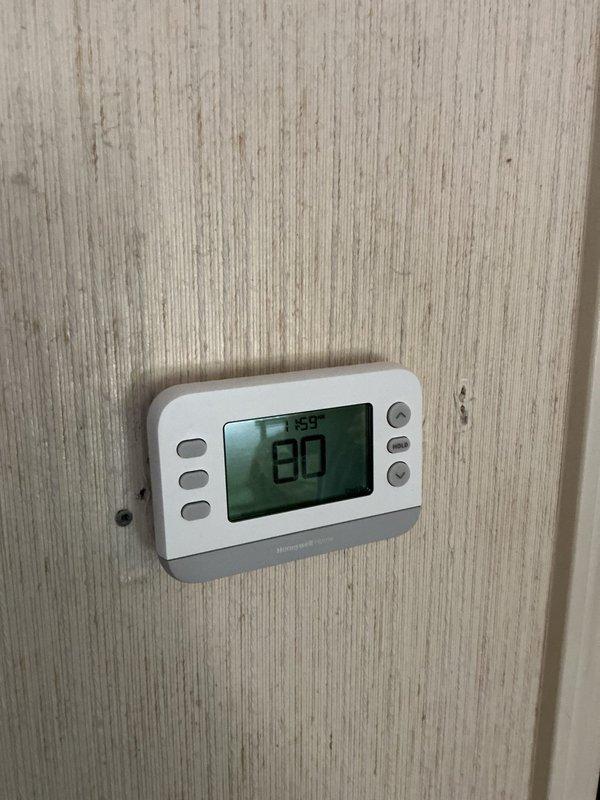 Responded to service call for basement air conditioning unit failing to maintain adequate cooling during hot weather. Upon arrival, verified thermostat display showing 80°F indoor temperature and confirmed system was running but not achieving setpoint. Performed diagnostic evaluation of AC system including visual inspection of indoor and outdoor components, electrical panel verification, and system performance assessment. Documented current operating conditions with photographs of thermostat readings and electrical panel configuration for service records.
