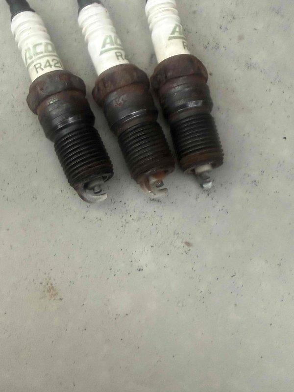 Performed scheduled maintenance on Kohler 48RCL standby generator unit. Replaced three spark plugs showing significant carbon buildup and electrode wear. Verified control panel operation and confirmed system settings; next maintenance interval properly displayed as 143 hours or August 2025. Unit tested in AUTO and RUN modes with successful operation confirmed.