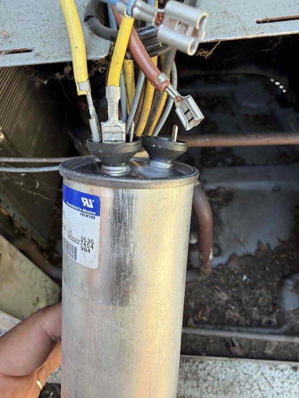 Responded to no cooling complaint with condenser fan not operating. Upon inspection, found failed dual run capacitor preventing outdoor fan motor from starting. Removed defective capacitor from condensing unit and installed new replacement capacitor with proper microfarad rating. Verified all electrical connections at terminal block were secure. Tested system operation and confirmed condenser fan motor running properly and unit cooling effectively.